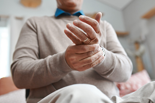 Man with arthritis massaging his hand.