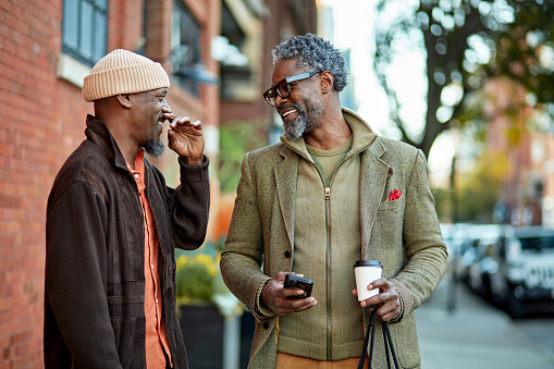 Two friends having a conversation on the street.