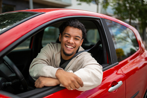 Happy man sitting in the driver's seat of his car.